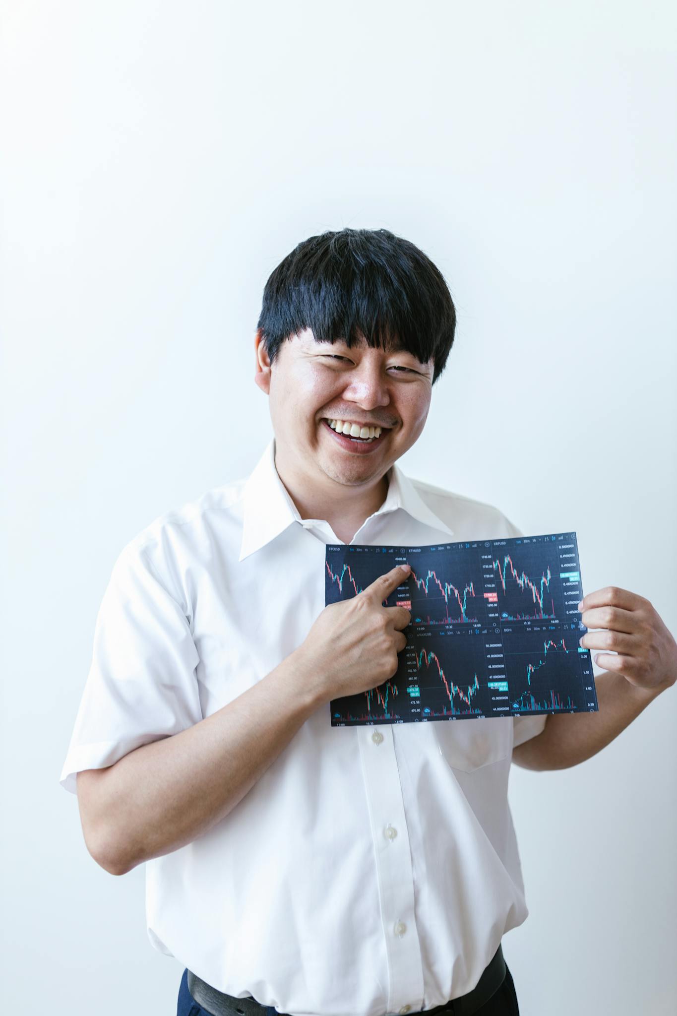 Smiling man holding a stock market chart, representing finance and trading.
